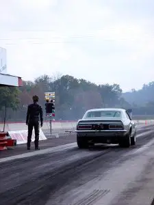 driver-standing-next-to-race-car